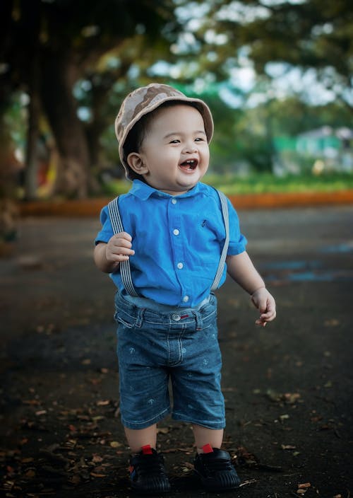 A baby boy wearing a hat and blue shirt