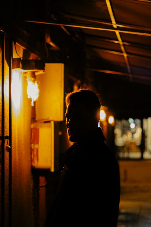 Free A dramatic silhouette of a person walking along the illuminated streets of Eskişehir at night. Stock Photo