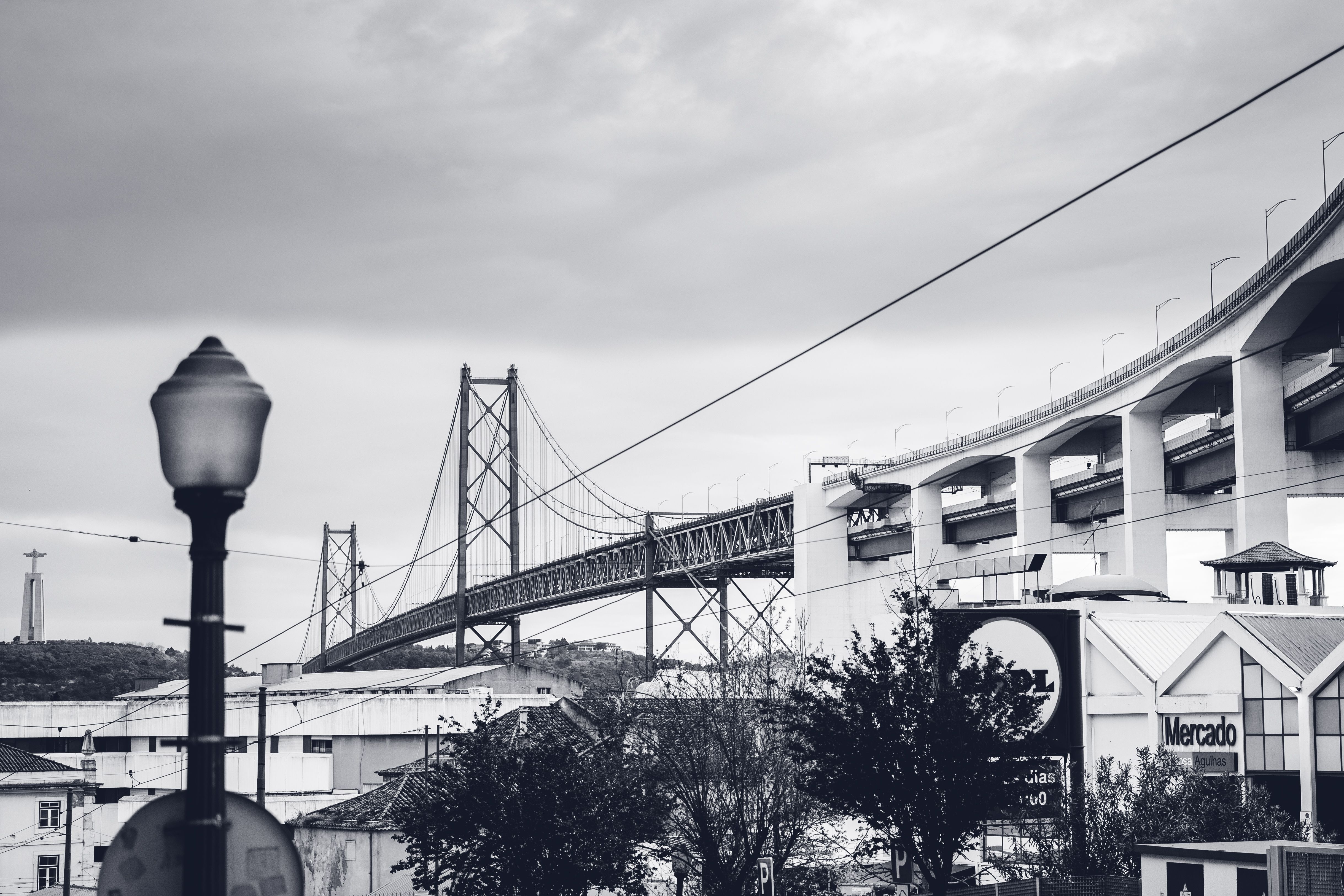 Black and white cityscape featuring the iconic suspension bridge in Lisbon, Portugal.