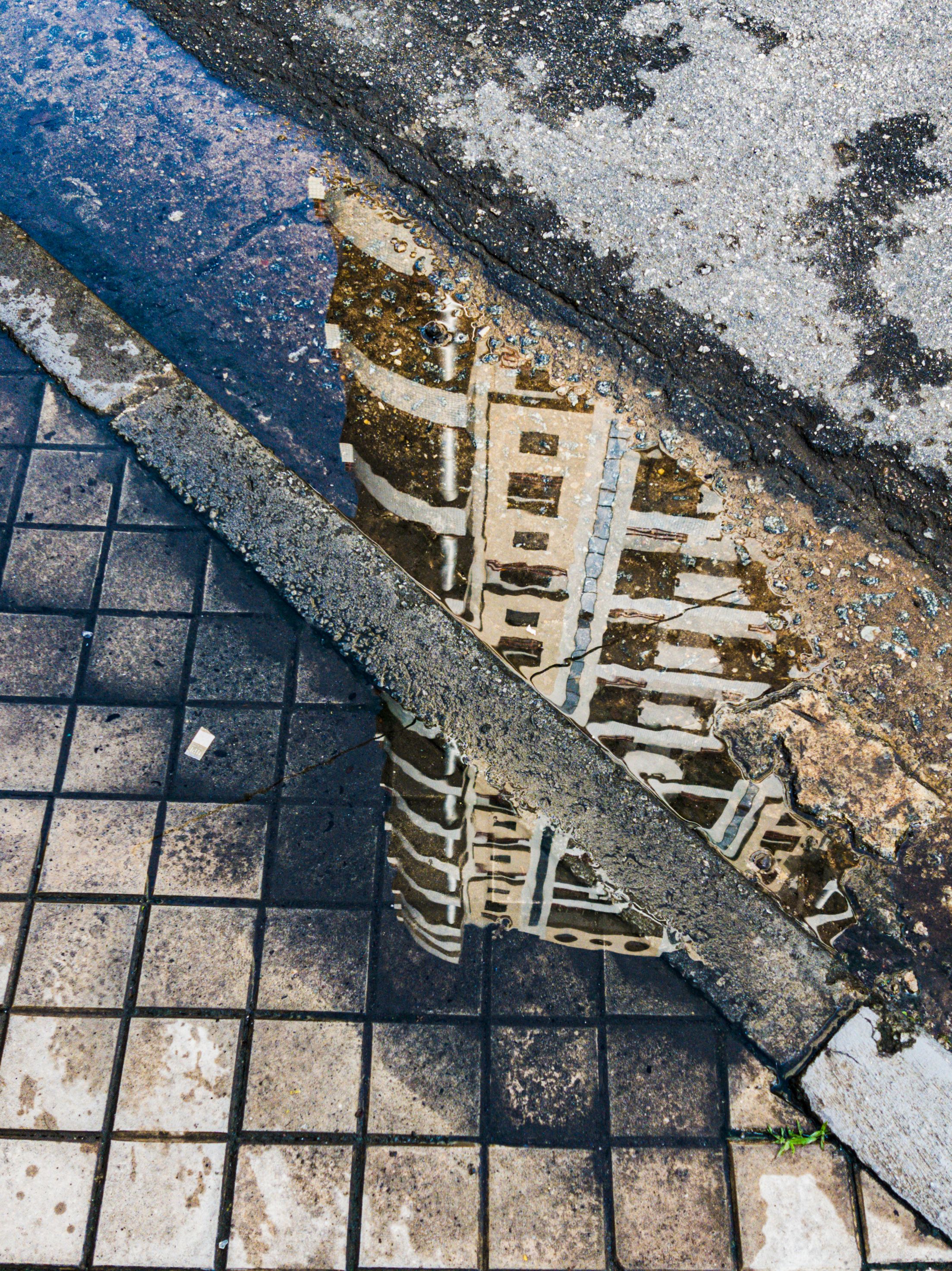 A reflection of a building in a puddle · Free Stock Photo