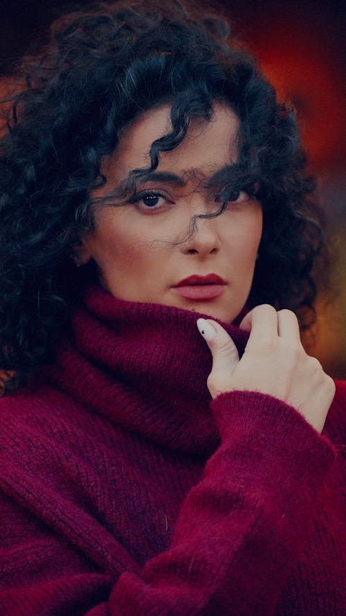 A woman in a red sweater and black makeup