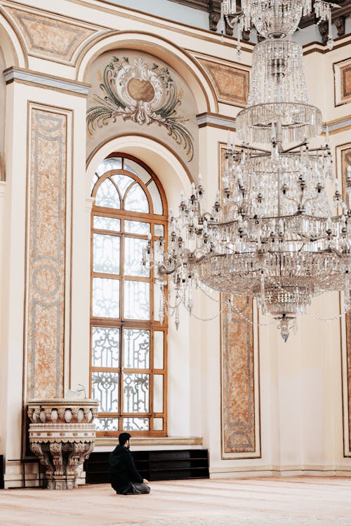 A woman sitting in front of a chandelier