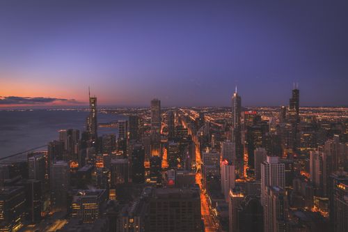 Free Beautiful aerial view of Chicago's illuminated cityscape at sunset. Stock Photo