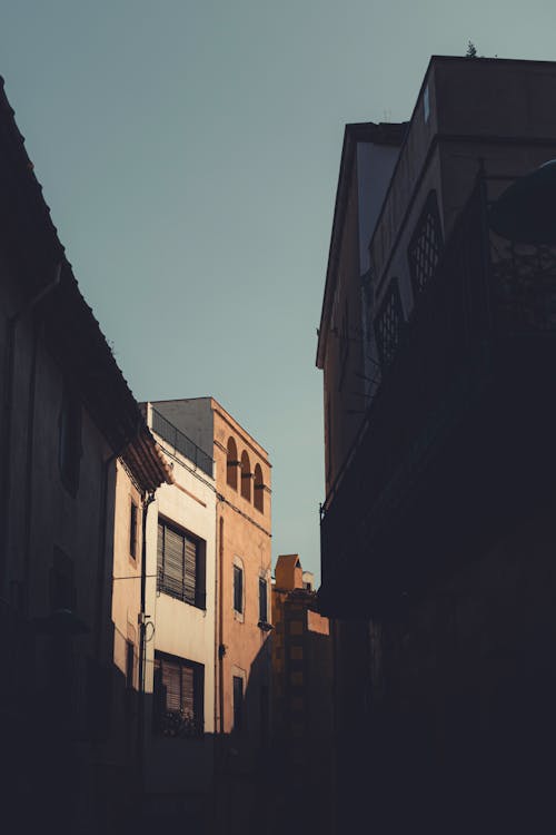 A photo of an alley with buildings and a sky