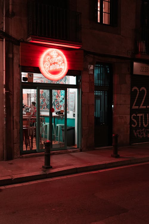 A neon sign is lit up in front of a restaurant