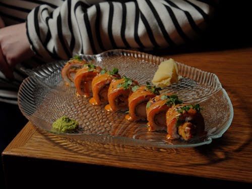 A person is sitting at a table with a plate of sushi