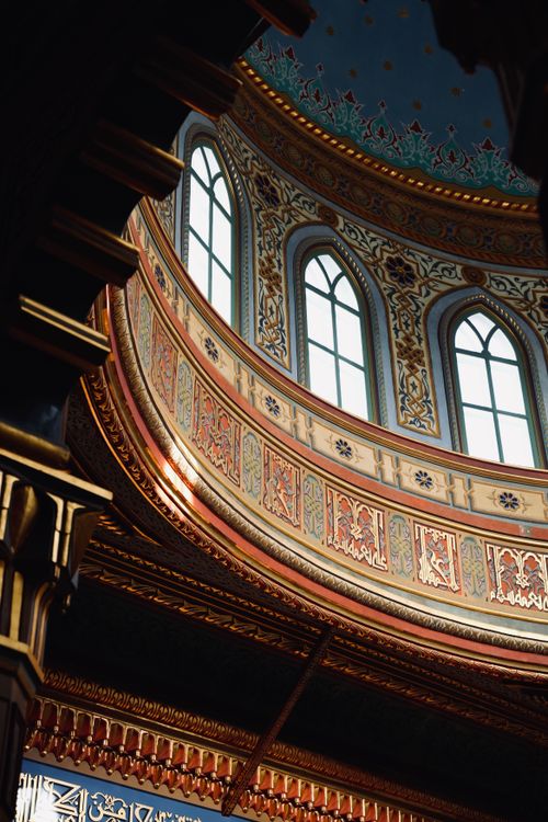 Free Detailed view of an elaborate mosque dome with intricate patterns and tall windows. Stock Photo