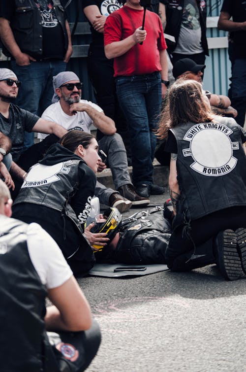 A group of people sitting on the ground with a motorcycle