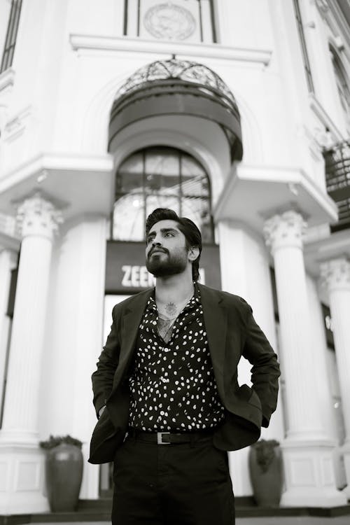 A man in a suit standing in front of a building