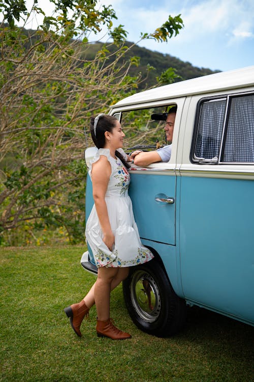 A woman and man standing next to a blue van