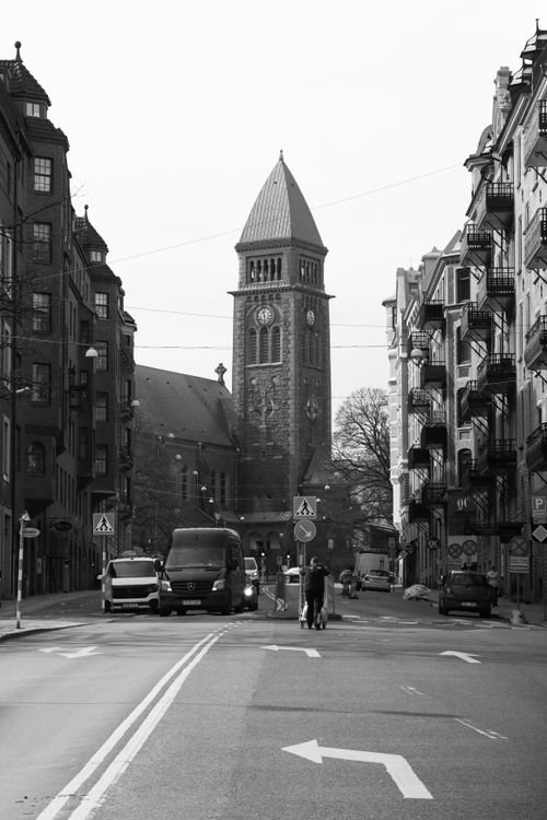 Free Black and white street view featuring church architecture in Gothenburg, Sweden with urban life presence. Stock Photo