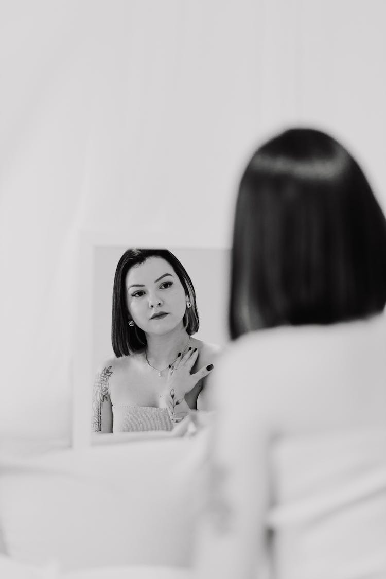 Beautiful Brunette Woman Looking At Reflection In Mirror