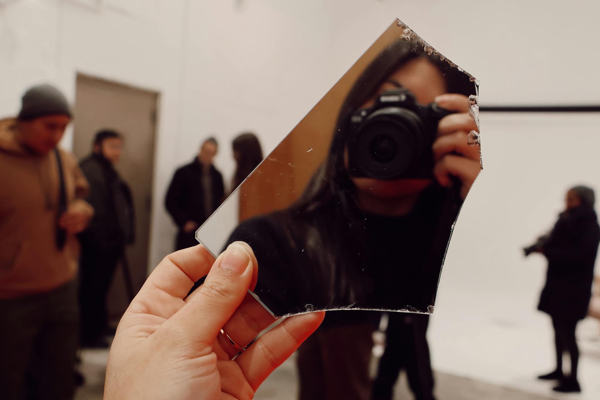 A photographer captures their reflection in a shard of glass during a creative shoot in a New York studio.