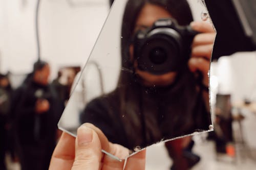 A person holding a camera in front of a mirror