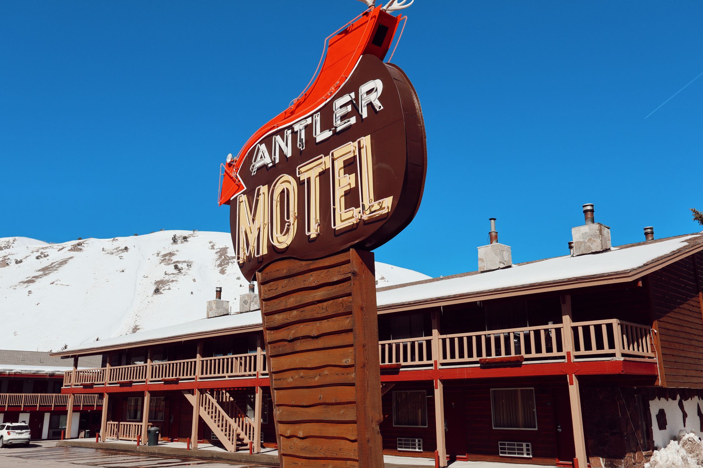 Iconic Antler Motel sign against snowy mountain backdrop in Jackson, Wyoming