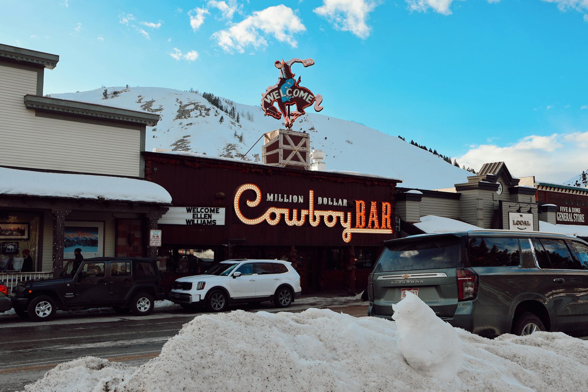 Iconic Million Dollar Cowboy Bar with snow-covered streets in Jackson, Wyoming during winter.