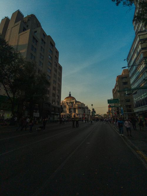 Free Discover the vibrant streets of Mexico City with Palacio de Bellas Artes at twilight, reflecting urban life. Stock Photo