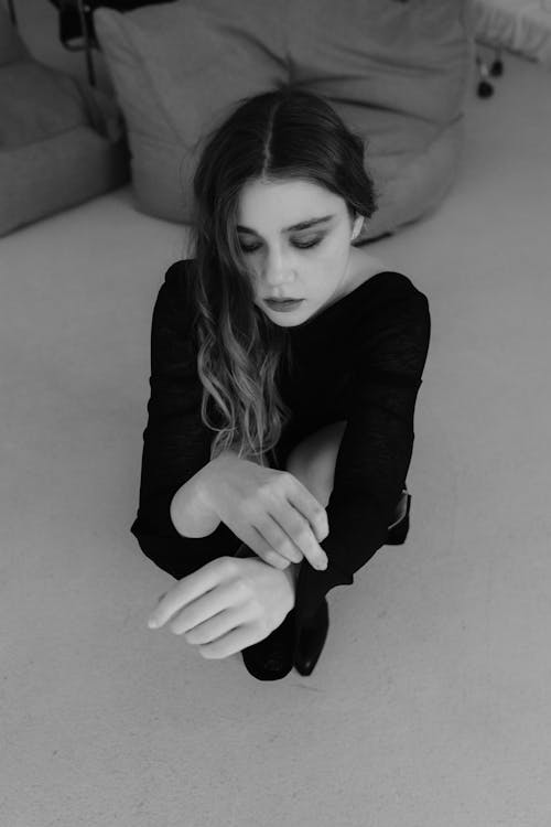 A woman in black and white sitting on the floor