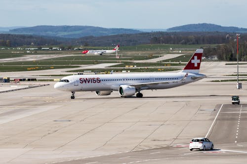 A swiss air plane on the runway at an airport