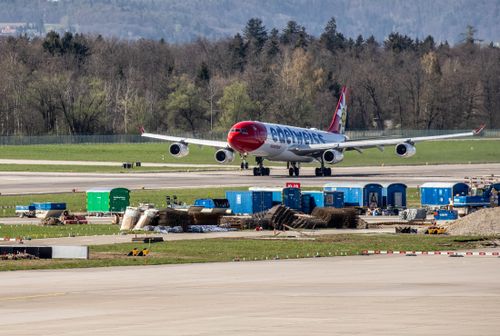 Free Edelweiss airplane taxiing at Zurich Airport with forest backdrop. Stock Photo