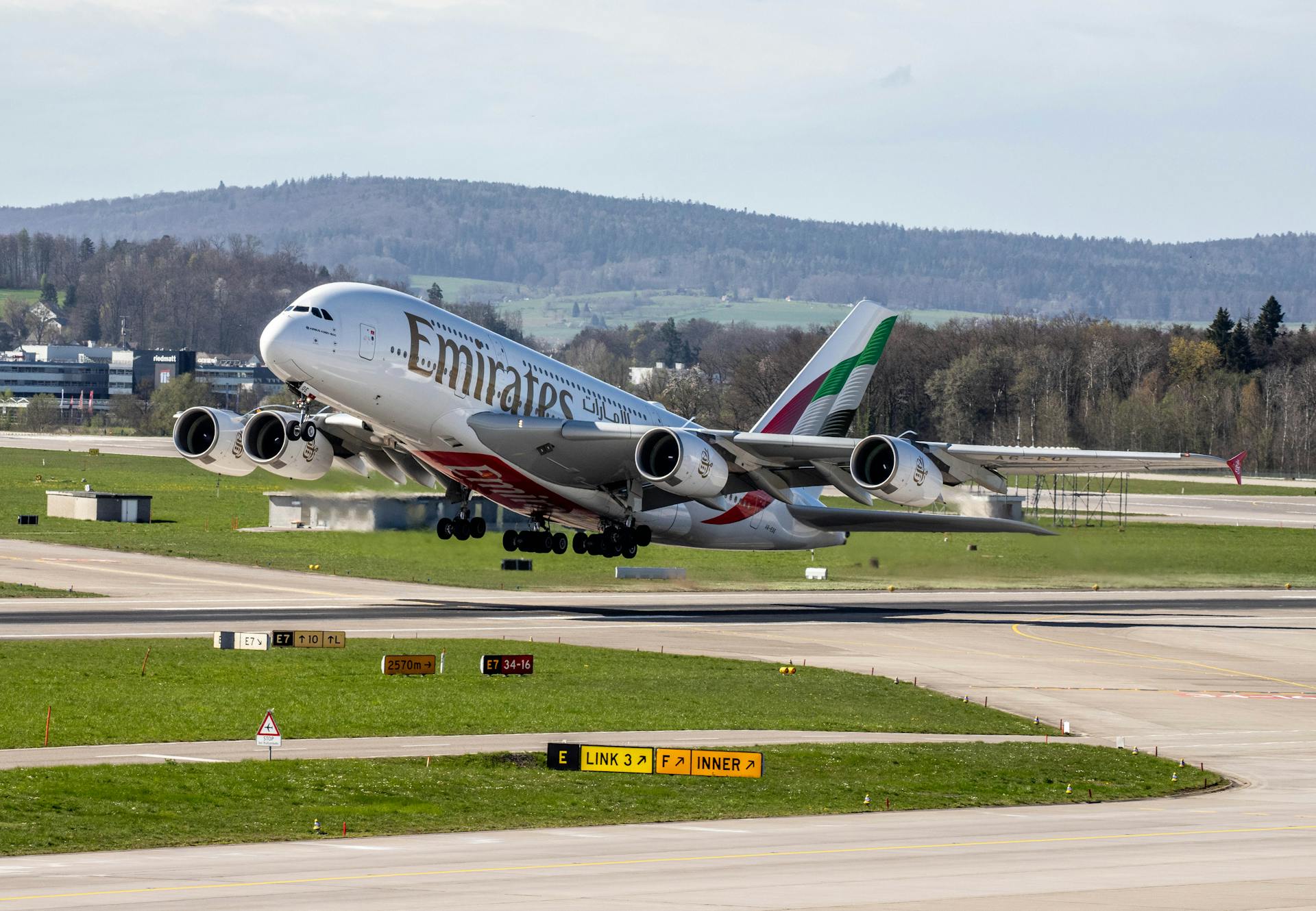 Emirates A380 aircraft lifting off from Zurich airport runway.