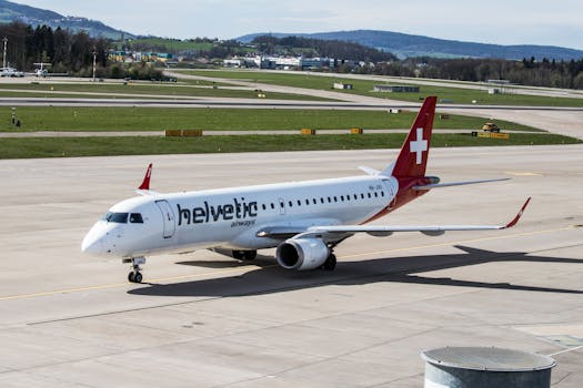 A Helvetic Airways aircraft on the runway at Zurich Airport during daylight.