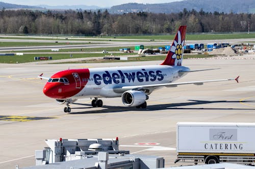 A red and white airplane sitting on the runway