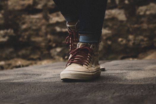 Close-up view of a sneaker with red laces on a textured surface, demonstrating modern street style.