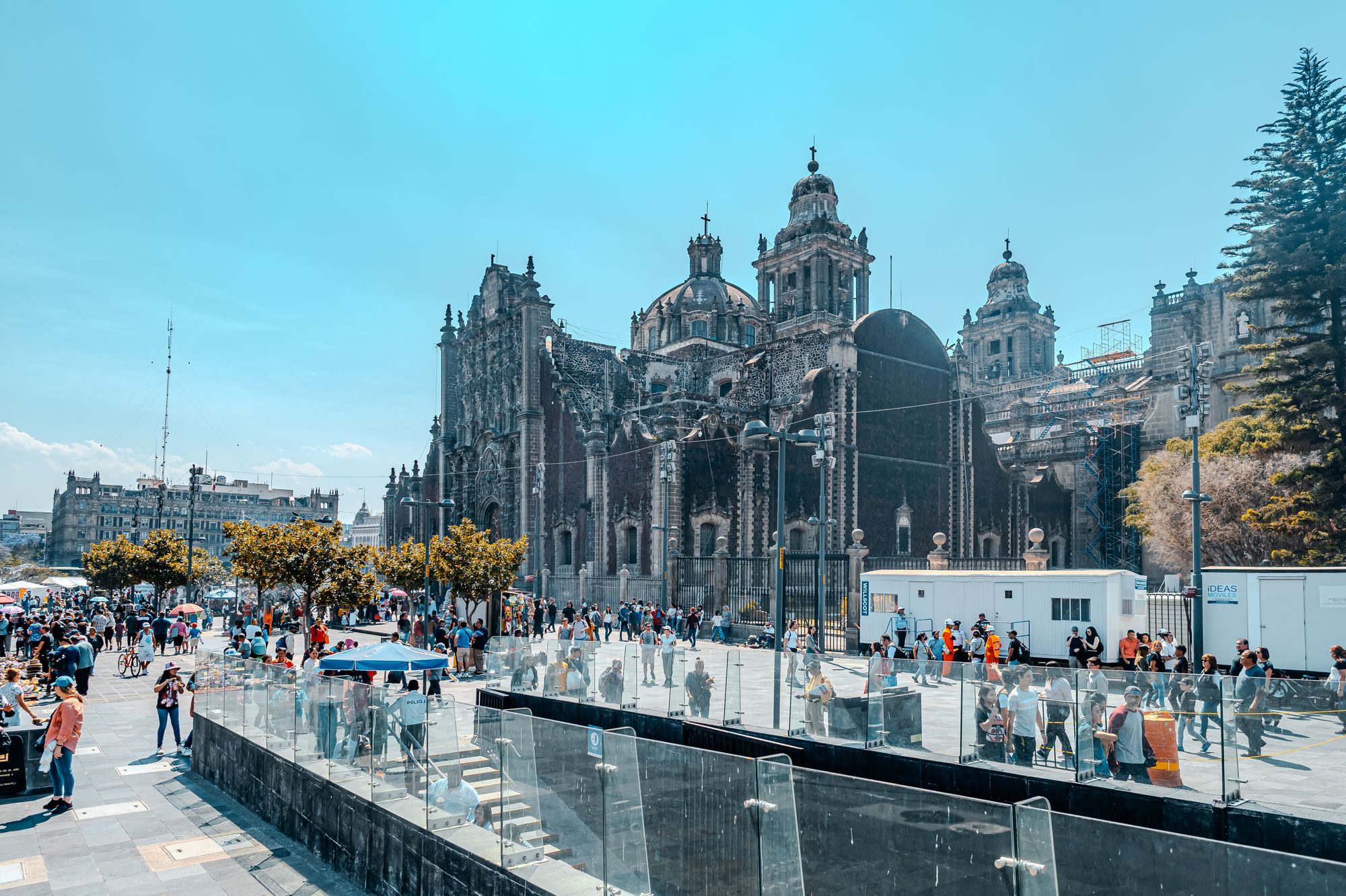 A bustling scene outside the iconic Metropolitan Cathedral in Mexico City, capturing urban life and architecture.