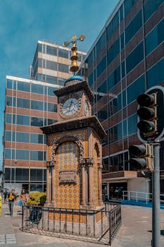 An iconic Ottoman clock tower stands amidst modern buildings in Mexico City.