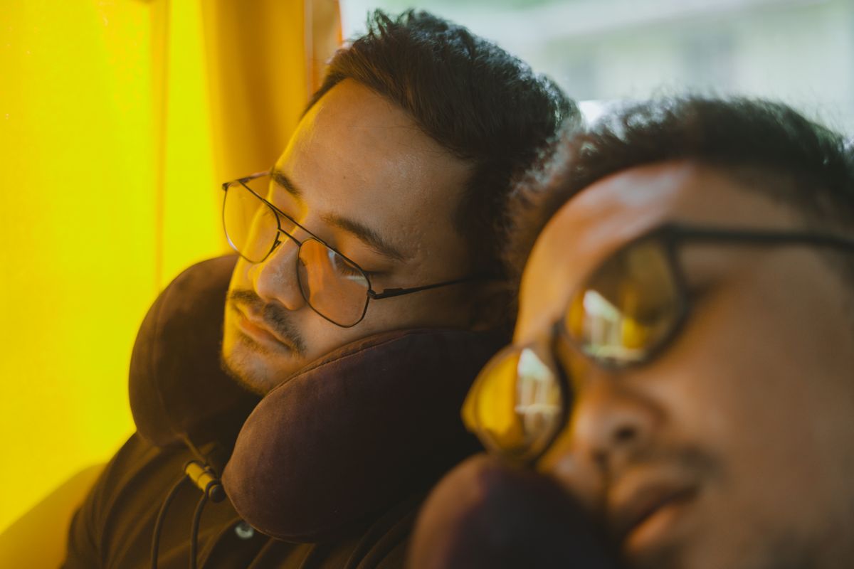 Travelers resting with neck pillows during a journey