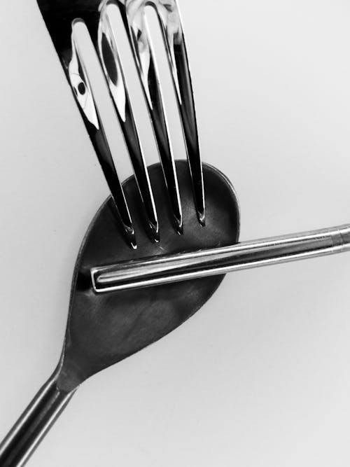 A fork with a spoon on top of it