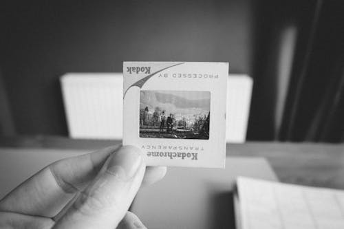 A person holding a small piece of paper with a picture of a mountain