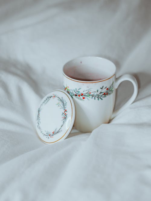 Free A cup and saucer on a bed with a blanket Stock Photo