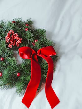 Beautiful Christmas wreath with conifer twigs and a red bow, perfect for holiday decoration.