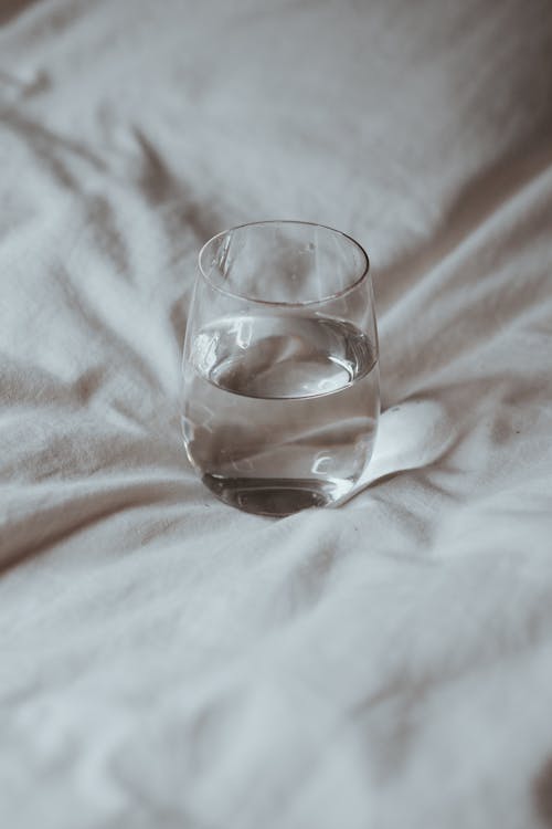 Glass of Water on White Sheet