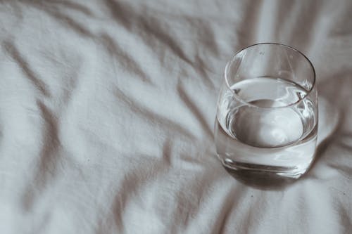 Free A glass of water on a bed Stock Photo