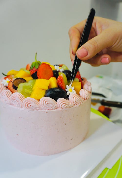 A person is cutting a cake with a fork