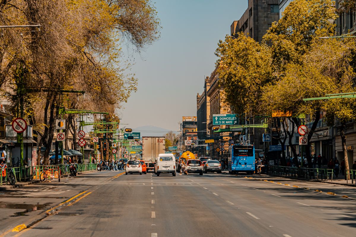 Captured in daylight, a vibrant Mexico City street with vehicles and urban life, highlighting city's dynamic energy.