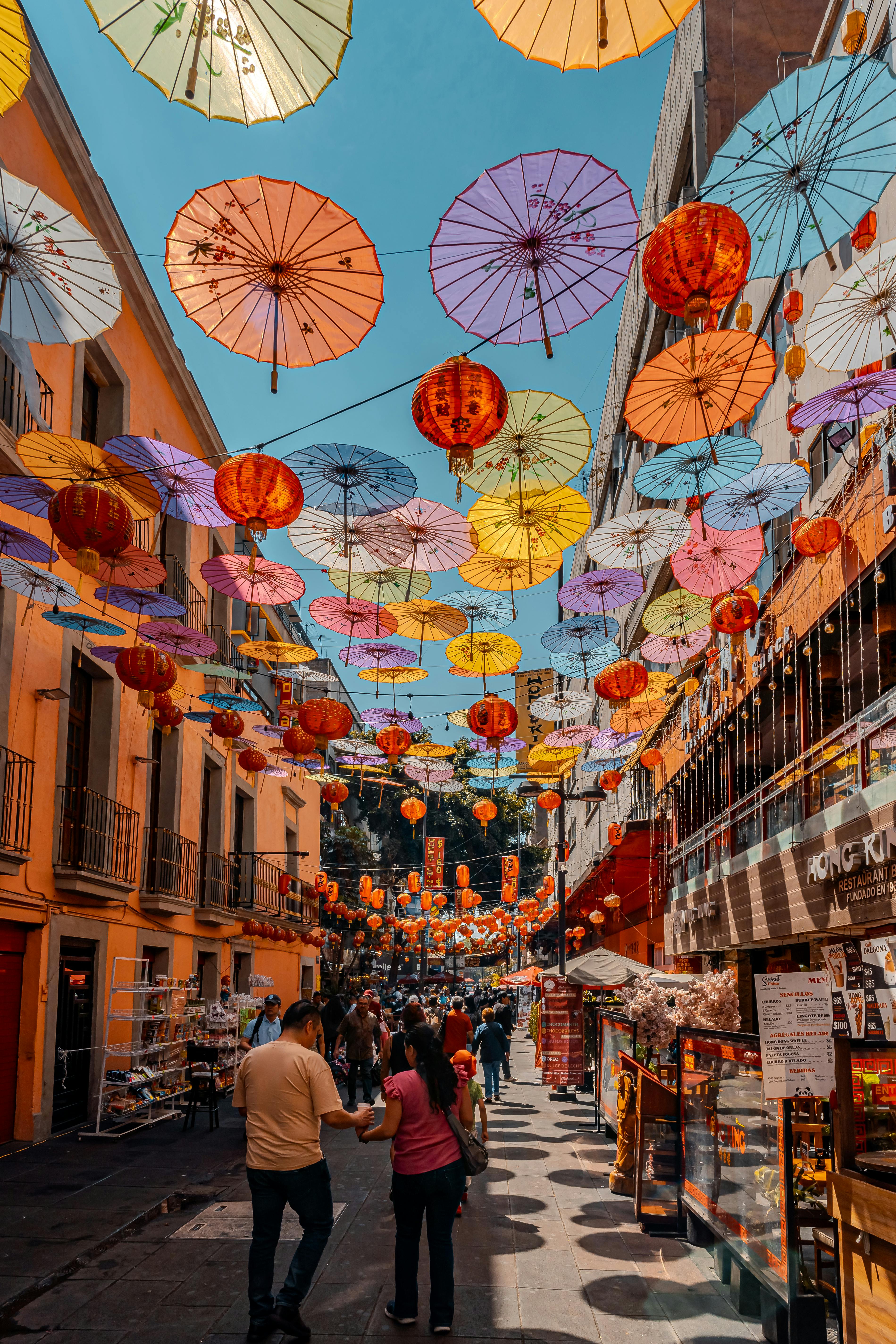 Colorful umbrellas decorating an outdoor market street in Ciudad de México, capturing cultural vibrancy and lively ambiance.