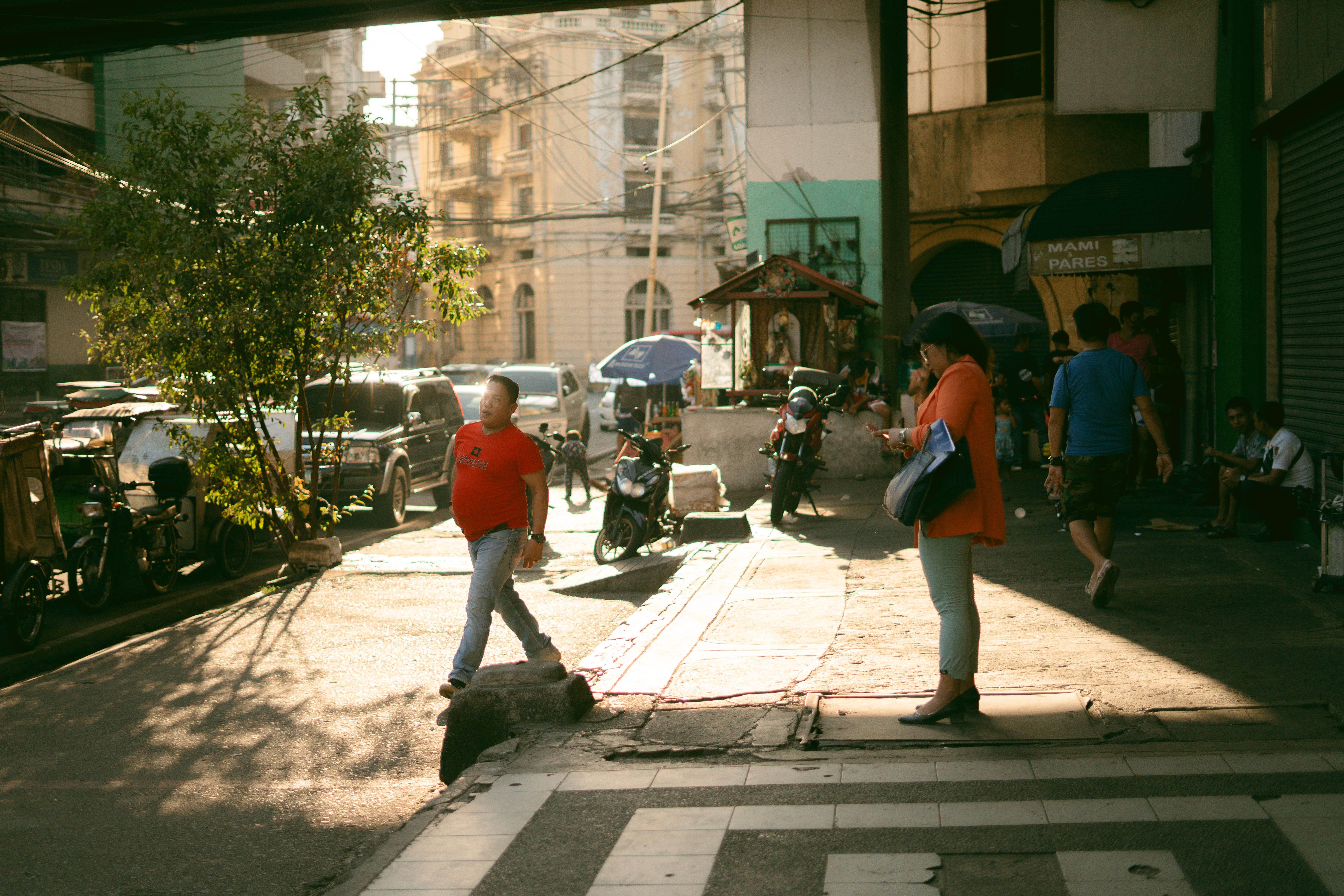 Busy Maynila street with pedestrians and vehicles in motion.