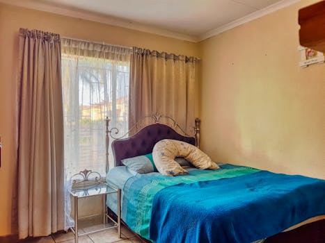 Comfortable bedroom with elegant decor and soft lighting, ideal for relaxation.