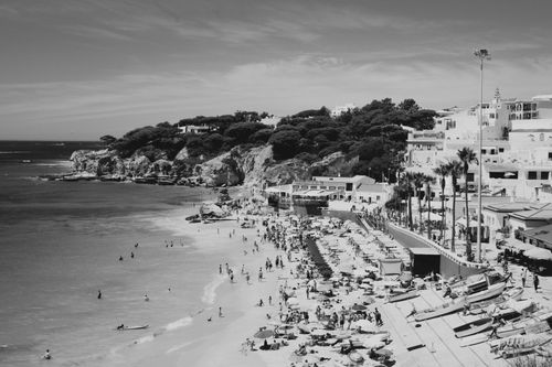 Free A stunning black and white aerial beach scene with people and coastal houses. Stock Photo