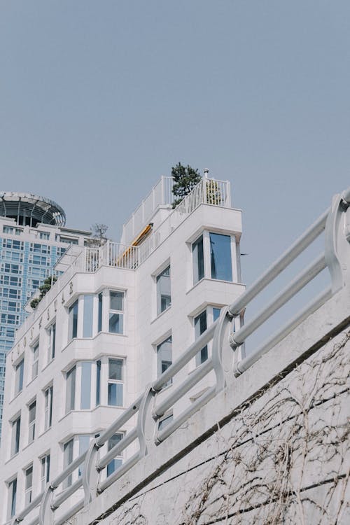 A white building with a blue roof and a balcony