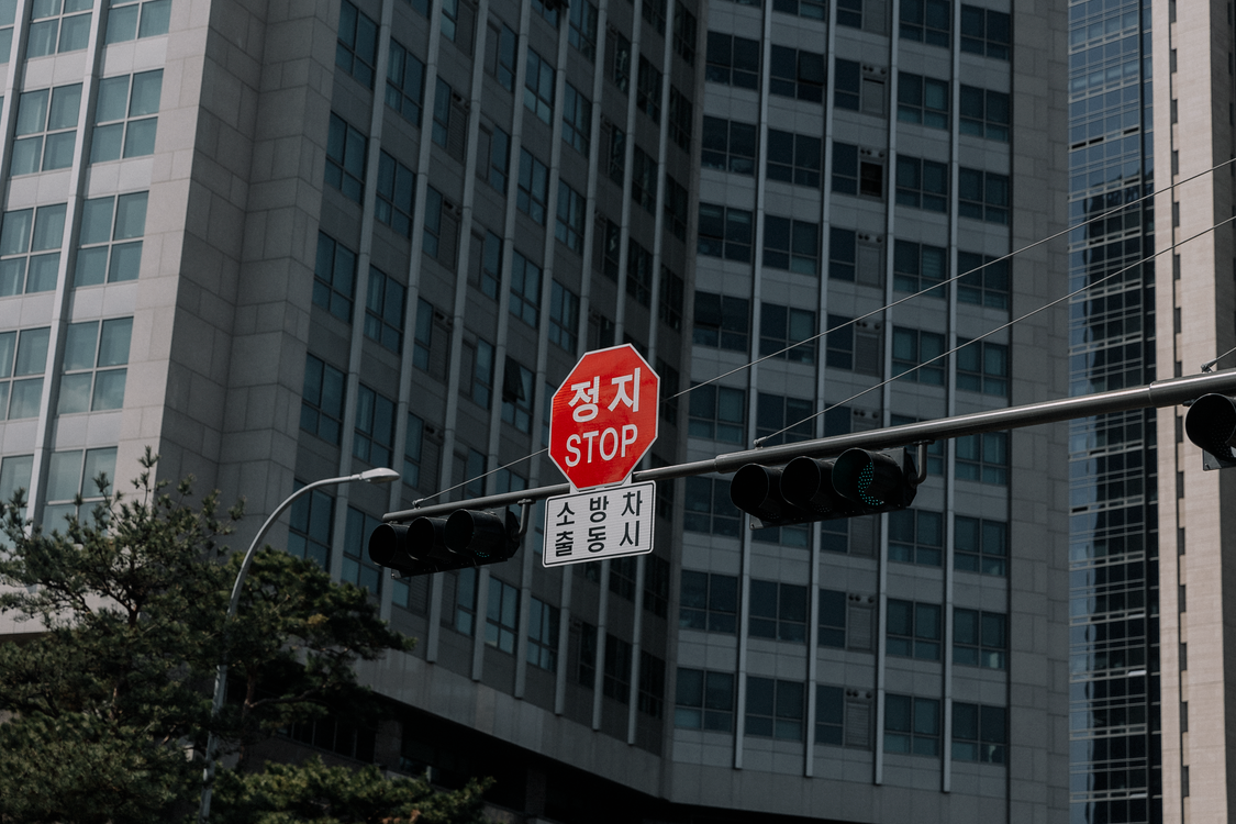 Stop Sign with a Korean Script, against a Block Facade · Free Stock Photo
