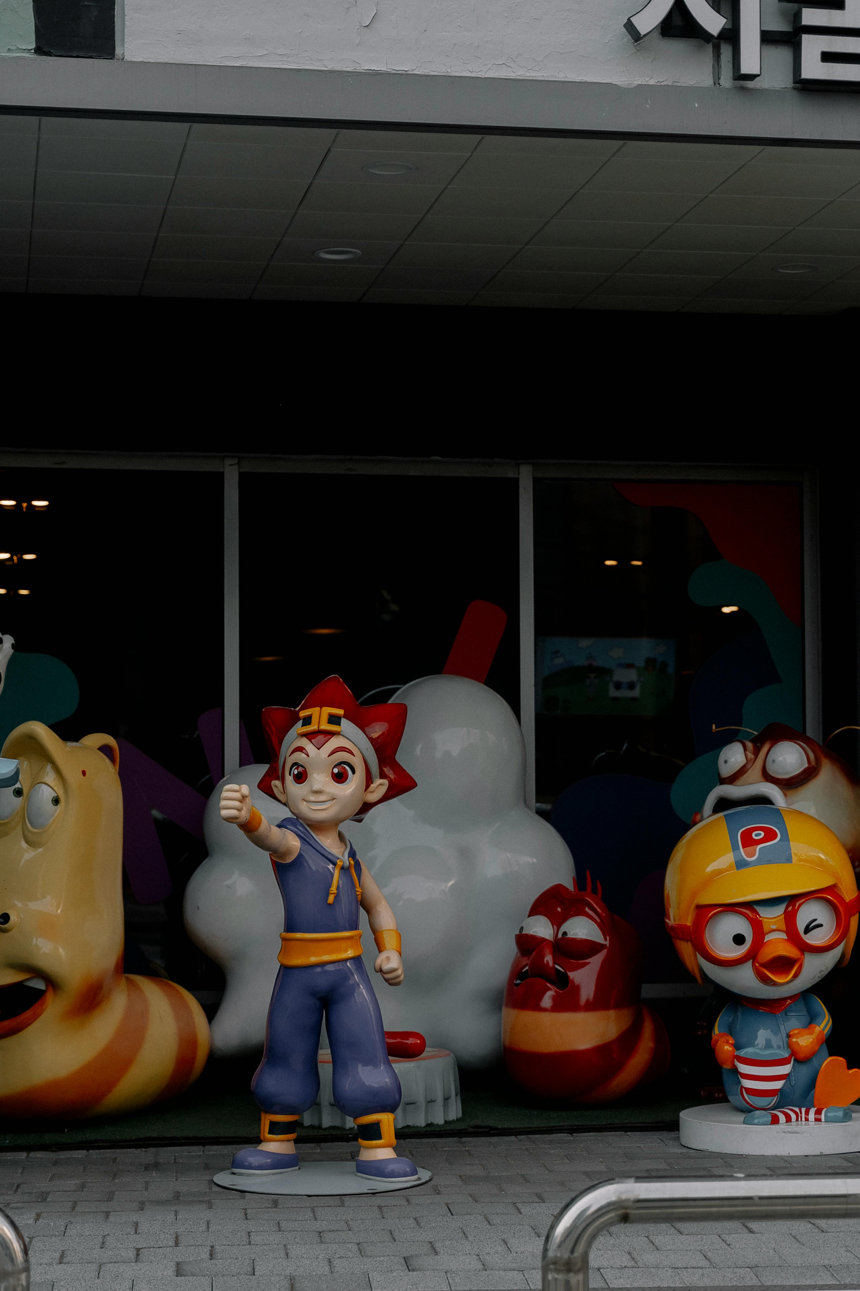 Vibrant statues of cartoon characters displayed outside a storefront.