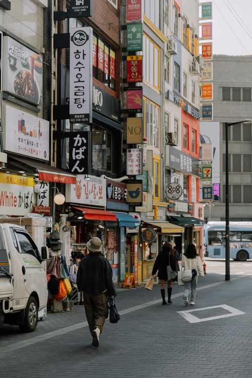 Free People walking on a vibrant street with colorful signs and buildings in an Asian metropolis. Stock Photo
