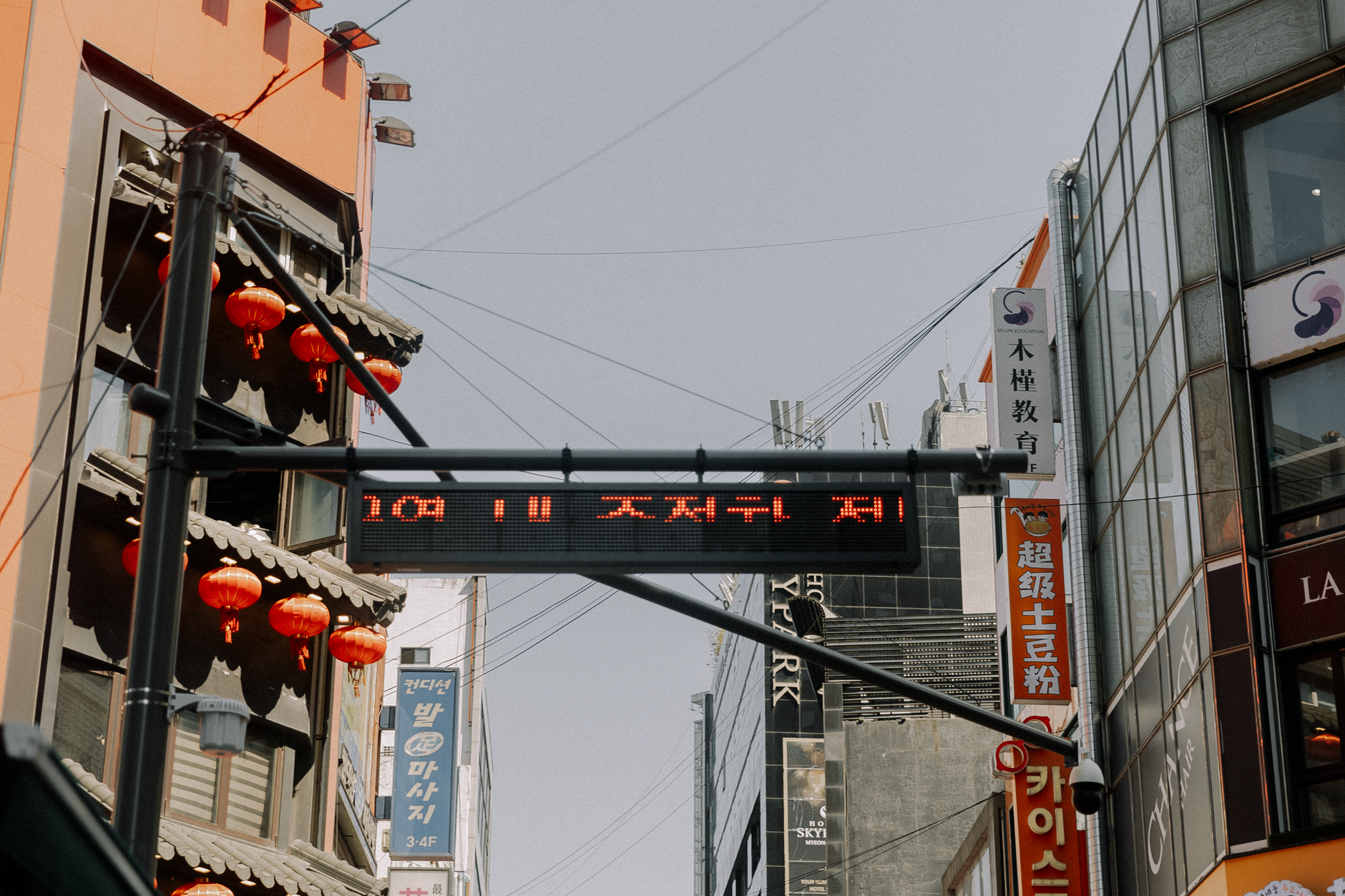 Dynamic urban scene with Asian-style architecture and red lanterns under digital screen.