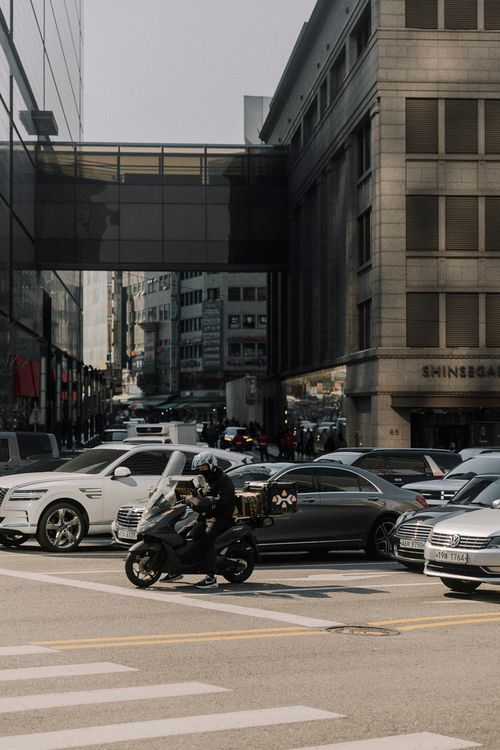 Free A bustling city street with cars and a motorbike in traffic, showcasing urban life. Stock Photo