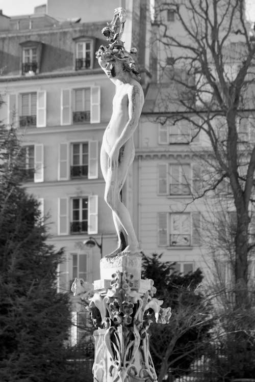 A statue of a woman in the middle of a park